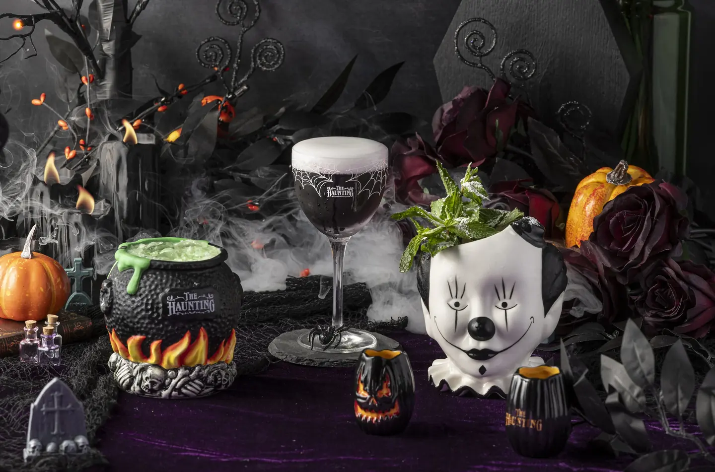 The Haunting cocktails in a cauldron, spiderweb goblet and clown mug